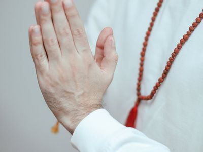 Hands in a prayer position, showing focus and presence.